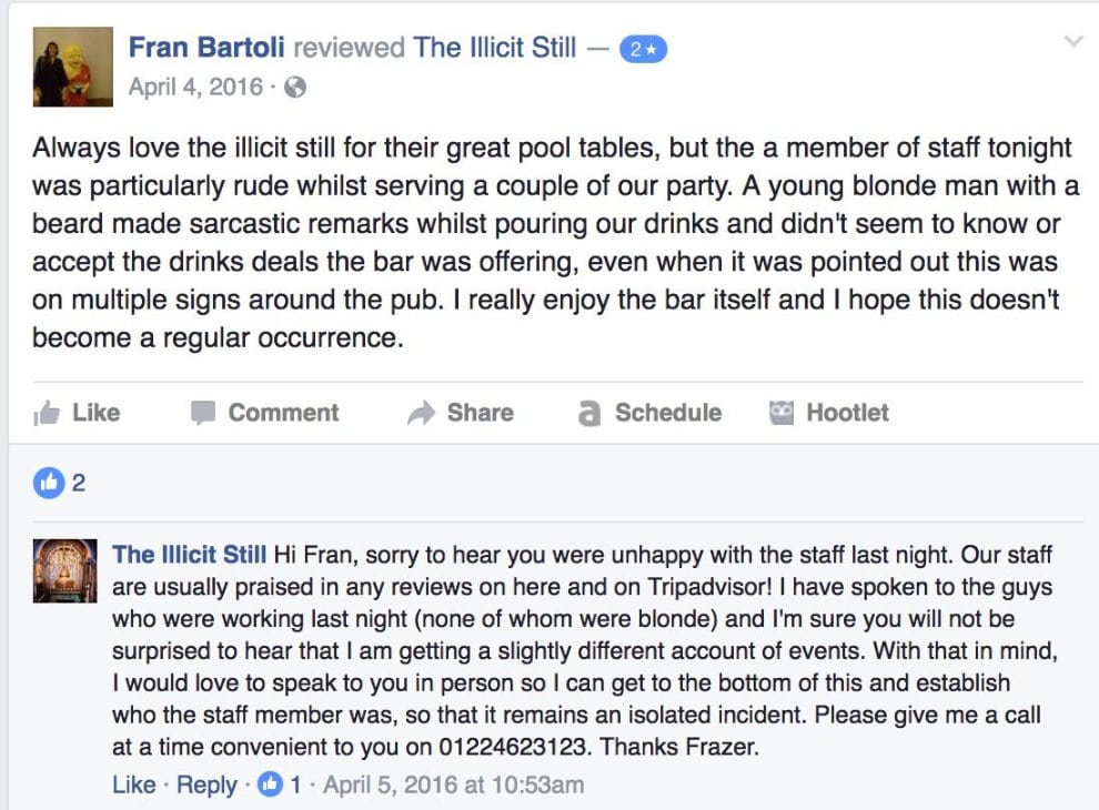 Schermata della pagina Facebook del bar The Illicit Still con una recensione negativa e la risposta articolata dello staff