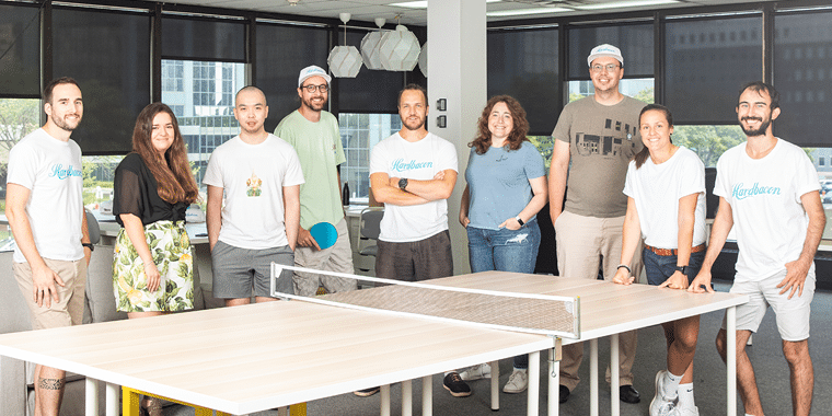 Hardbacon's team of employees around a pingpong table
