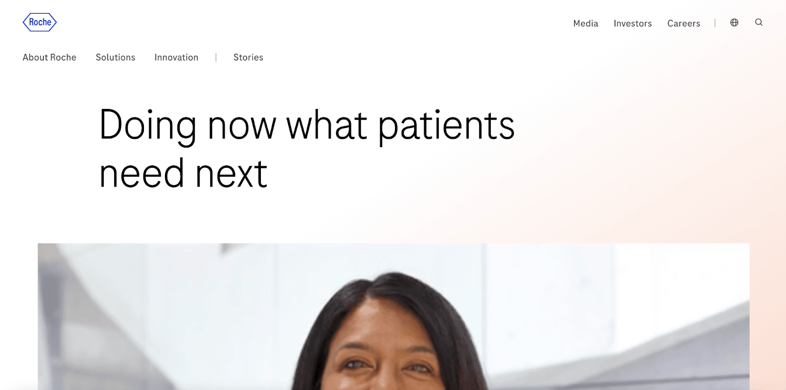 Una captura de pantalla que muestra la página oficial de Roche con el texto "Doing now what patients need next" (Haciendo ahora lo que los pacientes necesitan a continuación) y la foto de una mujer sonriente.