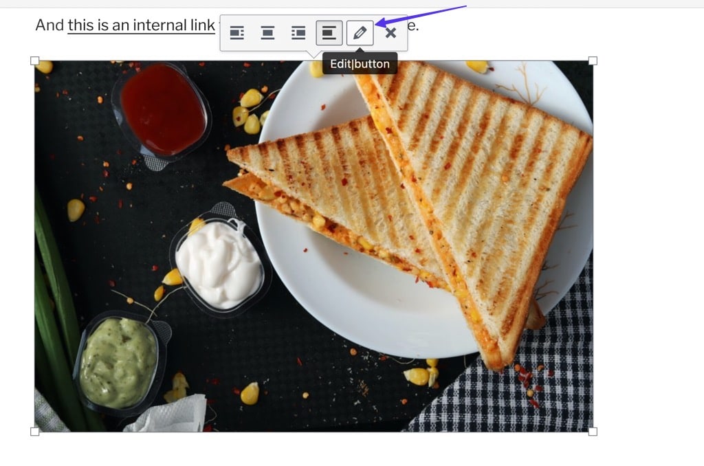 Schermata di un articolo nell’editor WordPress: l’immagine centrale è selezionata e compare il menu delle opzioni immagine. Una freccia indica l’icona della matita e l’etichetta Edit button