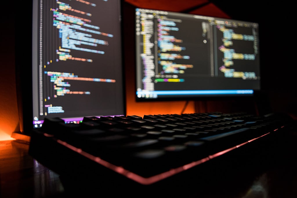 Computerschermen met code die door verschillende soorten ontwikkelaars wordt gebruikt