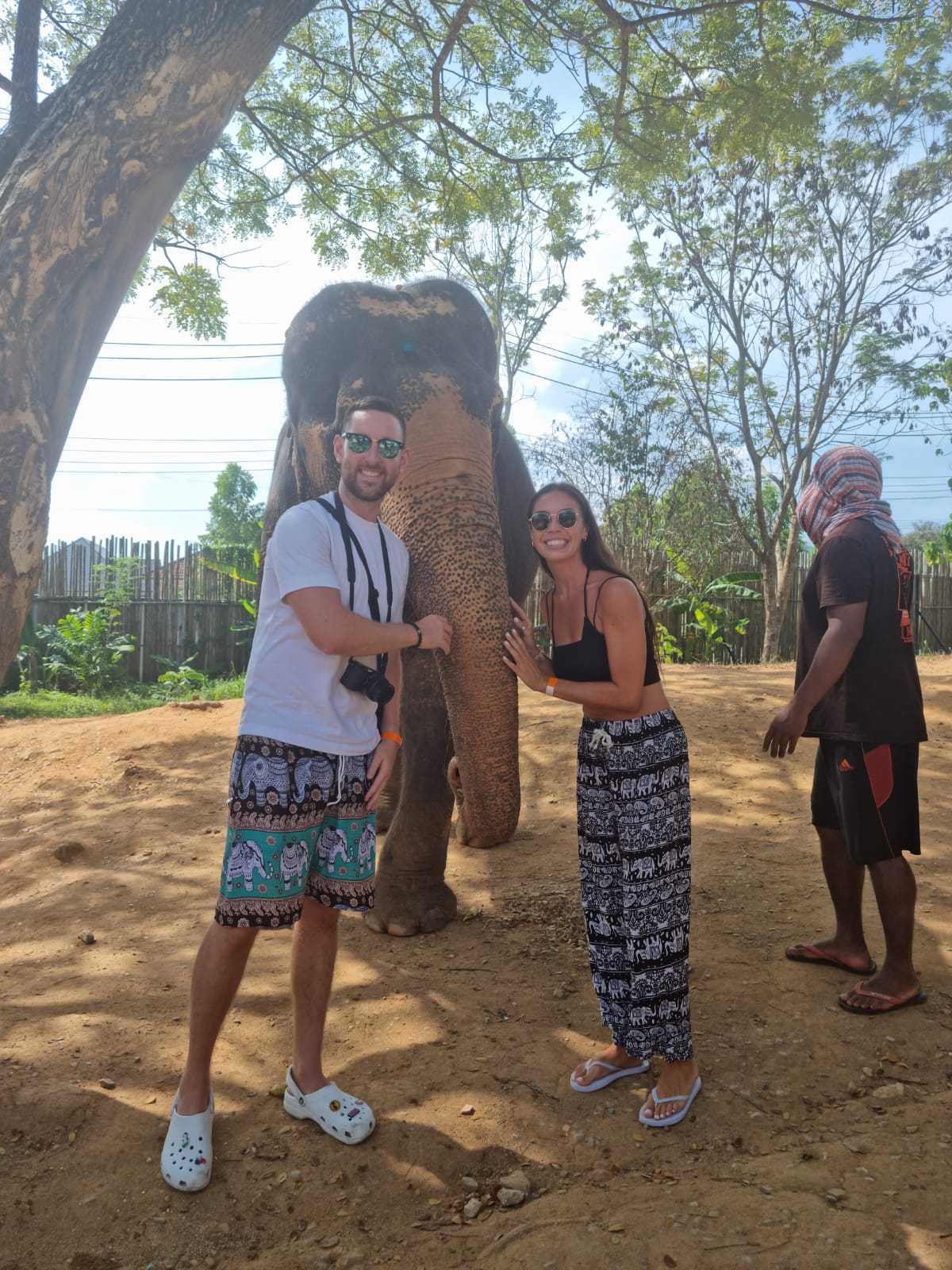 Un hombre y una mujer junto a un elefante.